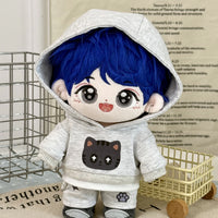 Plush toy with blue hair and a cat-themed hoodie on a surface with text in the background